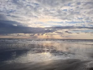 Sunlight emerging through clouds on a beach