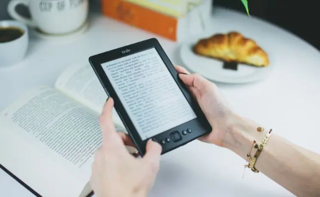 Image of reading a kindle at breakfast table