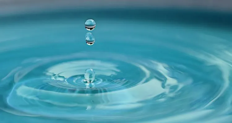 Image of a water dropping into clear water, symbolising water conservation.